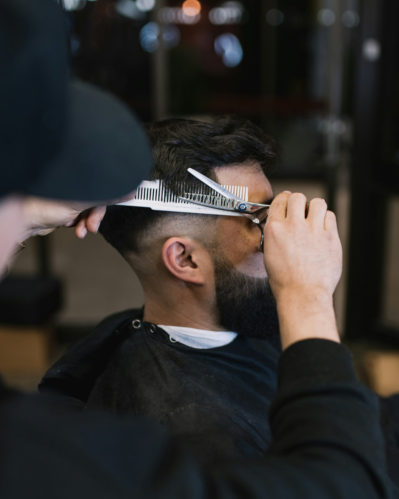 Hair stylist cutting a client's hair in a salon